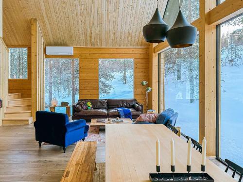 a living room with a couch and a table at Kimmelvilla Pyhä - Ski-in, modern design and spectacular scenery in Pyhätunturi