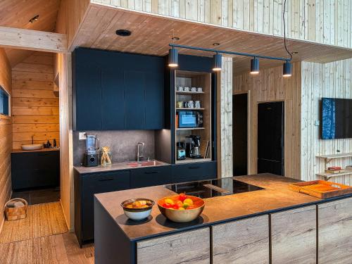 a kitchen with blue cabinets and a bowl of fruit on a counter at Kimmelvilla Pyhä - Ski-in, modern design and spectacular scenery in Pyhätunturi