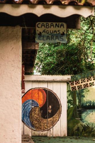 a sign on the side of a building with a painting at Aldeia Gaia Chalés in Teresópolis