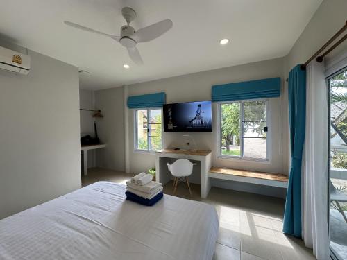 バーン・タイにあるSand Terrace Beach Bungalowsのベッドと机と窓のある寝室