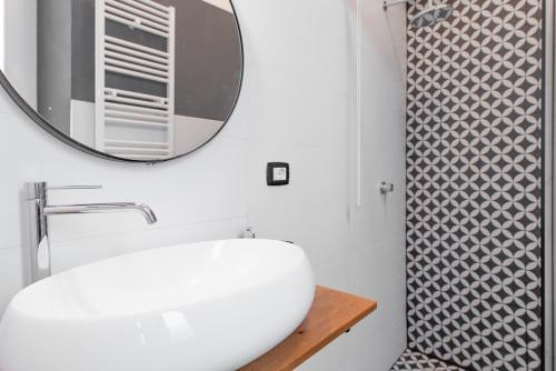 een badkamer met een witte wastafel en een spiegel bij Appartamento Lingotto in Turijn