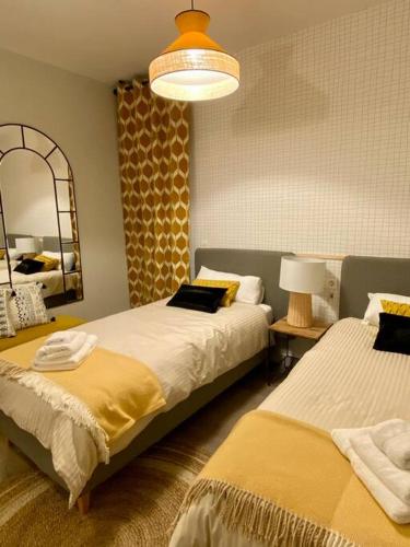 1 dormitorio con 2 camas y un espejo grande en Nuevo Moderno Apartamento de Lujo en Sevilla