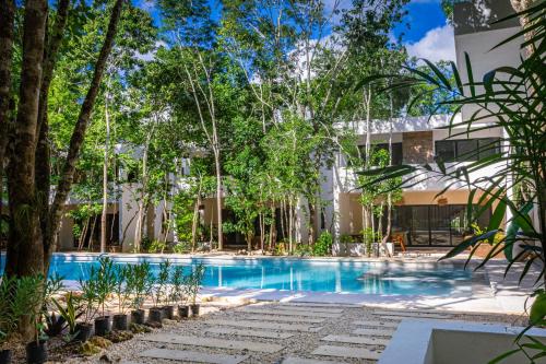 una piscina frente a un edificio con árboles en Aqua Viva, Pool, AC, Internet, Beach club, en Bacalar