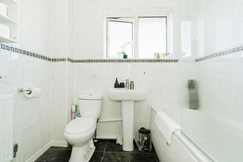 Un baño con inodoro, lavabo y bañera. en Canterbury 3BR close to shops with Free Parking, en Kent