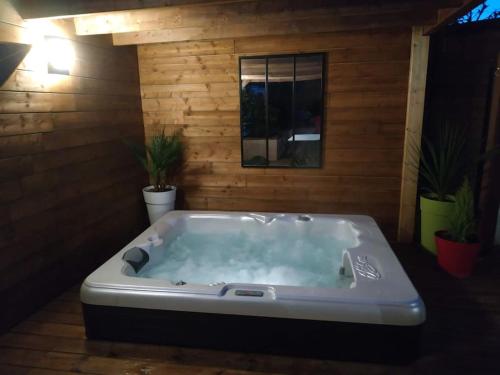 Studio jacuzzi privé à 8 min à pied de la plage في لاسيوتا: حوض استحمام كبير في غرفة بها نباتات