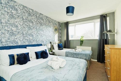 a bedroom with two beds with towels on them at Gema Home - Charming Canterbury Home with private parking perfect for vans in Kent