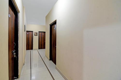 a hallway with doors and a tile floor and a corridor at OYO Archie Oasis in Bhubaneshwar