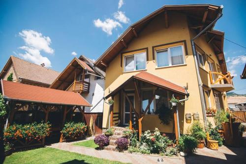 een huis met bloemen ervoor bij Balázs Panzió in Corund