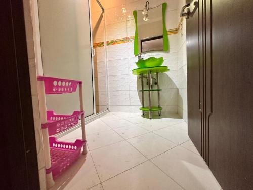 - une salle de bains avec des chaises roses et vertes dans la chambre dans l'établissement Atomium, à Agadir