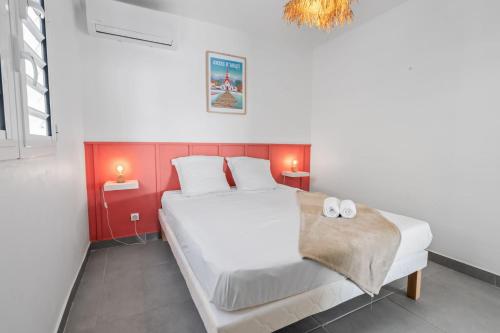 1 dormitorio con 1 cama blanca grande y cabecero rojo en Villa Kaz Kreyol, en Les Anses-dʼArlet