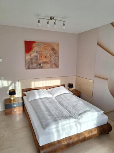 a bedroom with a bed with white sheets and a painting at Casa Blanca in Wirges