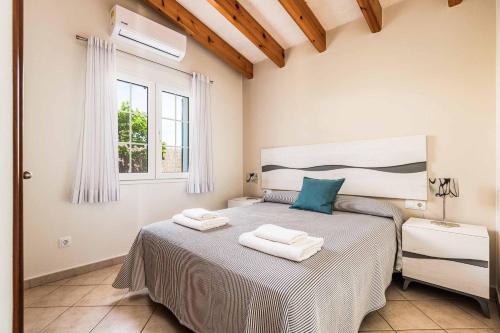 a bedroom with a bed with two towels on it at Villa Sara Porter in Cala'n Porter