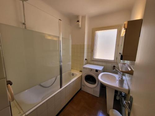 uma casa de banho com um lavatório e uma máquina de lavar roupa em Location appartement propriano em Propriano