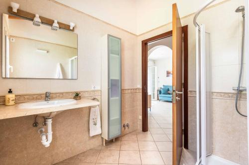 a bathroom with a sink and a mirror at Villa Sara Porter in Cala'n Porter