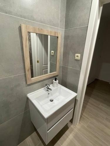 La salle de bains est pourvue d'un lavabo blanc et d'un miroir. dans l'établissement Appartement Brussels Airport, à Machelen