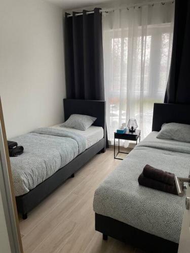 - une chambre avec 2 lits et une fenêtre dans l'établissement Appartement Brussels Airport, à Machelen