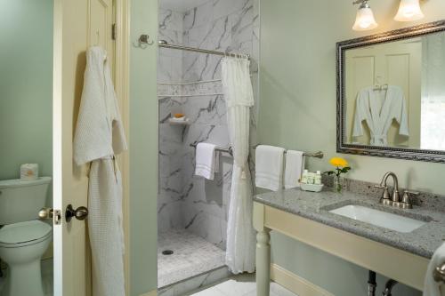 a bathroom with a toilet and a sink and a shower at The Queen Victoria in Cape May