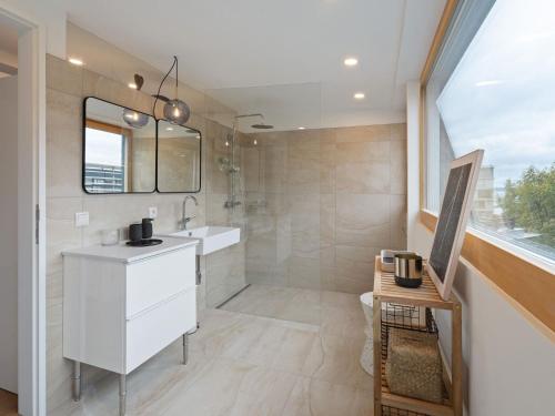a bathroom with a white sink and a shower at Traumhafte Stadtwohnung mit Blick auf den Bodensee in Bregenz