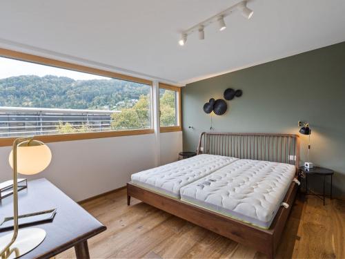 a bedroom with a bed and a large window at Traumhafte Stadtwohnung mit Blick auf den Bodensee in Bregenz