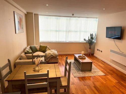 a living room with a table and a couch at Central 2 Bedroom Apartment - Fast WIFI - Near Broad Street in Birmingham