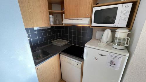 une petite cuisine avec un micro-ondes et un réfrigérateur dans l'établissement Evasion Pyrénéenne, à Luchon