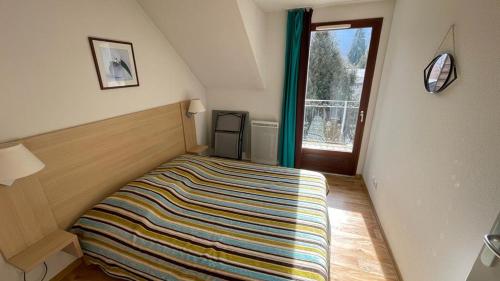 - une chambre avec un lit et une couverture colorée dans l'établissement Evasion Pyrénéenne, à Luchon