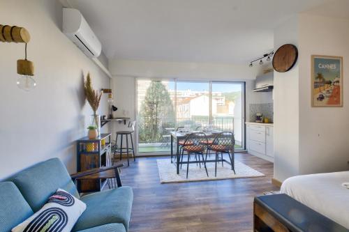 un salon avec un canapé bleu et une table dans l'établissement Magnifique studio avec terrasse au cœur de Cannes, à Cannes