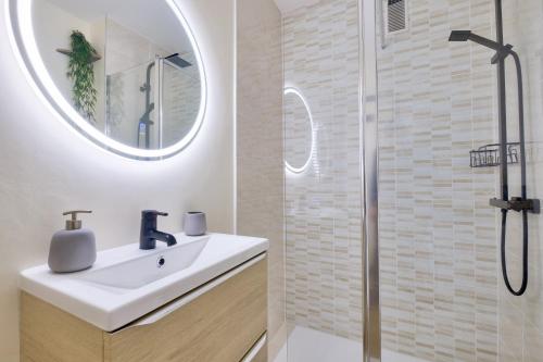une salle de bain blanche avec un lavabo et une douche dans l'établissement Magnifique studio avec terrasse au cœur de Cannes, à Cannes