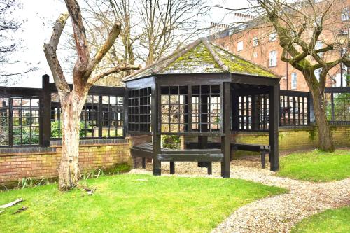 a park with a bench in front of a fence at Balcony Breeze - Reading City Centre in Reading