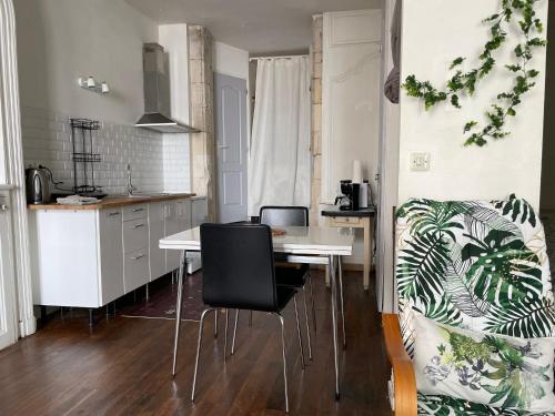 une cuisine avec une table et des chaises dans une pièce dans l'établissement Loft de la plage Concurrence, à La Rochelle