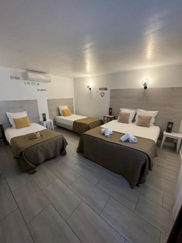 a hotel room with two beds in a room at Hôtel Le Médiéval in Aigues-Mortes