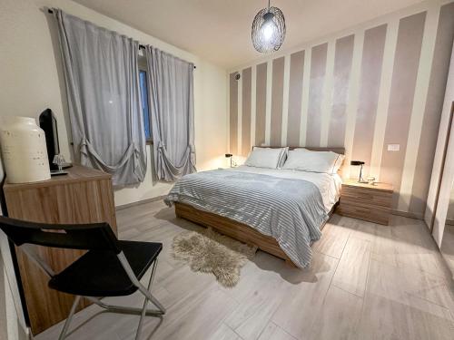 ein Schlafzimmer mit einem Bett, einem Stuhl und einem TV in der Unterkunft La Rosa dei Venti con parcheggio e ampio giardino in centro in Lucca
