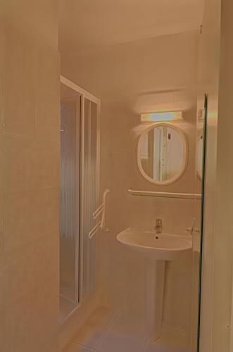 une salle de bain avec un lavabo et un miroir dans l'établissement Appartement Les Couchants PORTICCIO, à Porticcio