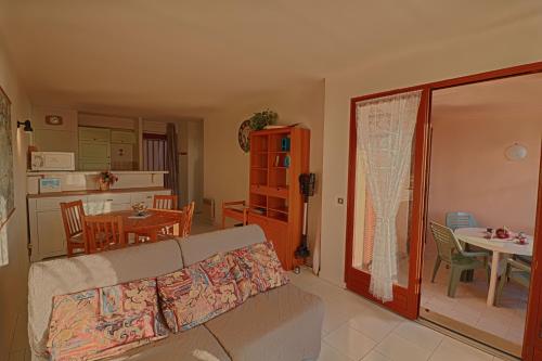 un salon avec un canapé et une salle à manger dans l'établissement Appartement Les Couchants PORTICCIO, à Porticcio
