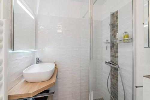 une salle de bain blanche avec un lavabo et une douche dans l'établissement Beau T2 avec terrasse proche des plages, à Marseille