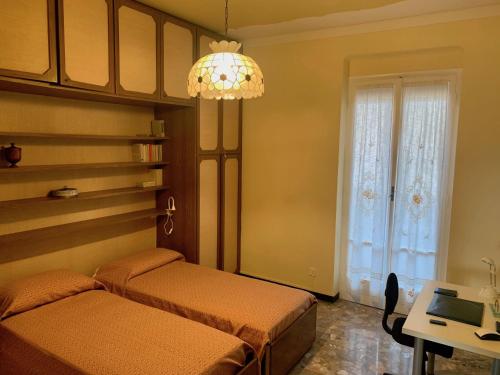 a bedroom with two beds and a chandelier at Casa Cele centro città vista mare in Ventimiglia