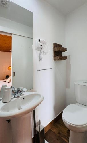 a white bathroom with a toilet and a sink at Sé Velha Suites in Coimbra