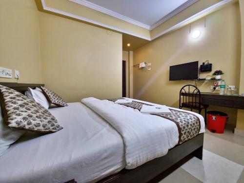 a hotel room with a bed and a television at BHIMAS INN -Puratchi Thalaivar Dr M G Ramachandran Central Railway Station Chennai in Chennai