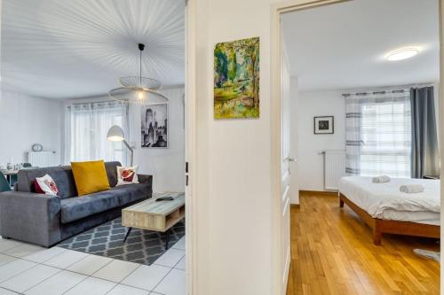 ein Wohnzimmer mit einem Sofa und einem Bett in der Unterkunft ZenBNB / Stella / Proche Gare / Garage / Wifi / in Annemasse