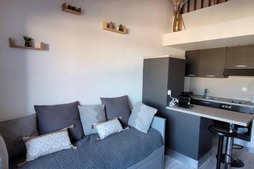 - un salon avec un canapé et des oreillers dans l'établissement Magnifique T1bis dans CALVI centre avec Parking, à Calvi