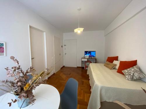 Habitación con 2 camas, mesa y TV. en Apartamento Carlota en Buenos Aires
