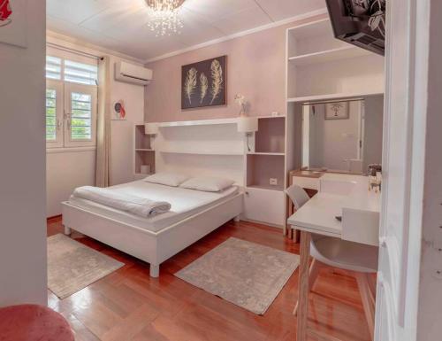 um quarto com uma cama, uma secretária e um lavatório. em Villa-Aquaterra-Hideaway-piscine-Barbecue em Matoury