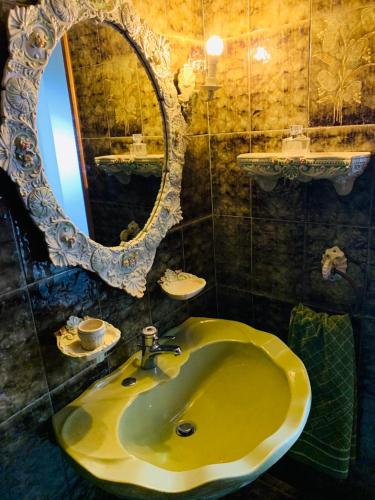ein Badezimmer mit einem gelben Waschbecken und einem Spiegel in der Unterkunft House Mario’s airport 2 in Spáta
