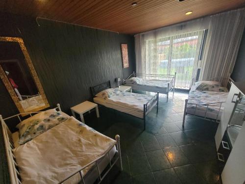 a room with three beds and a table and a window at Hani's Partyhaus in Verl
