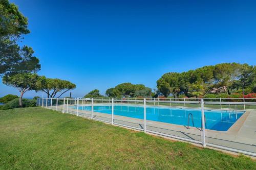 une piscine entourée d'une clôture dans l'établissement Appartement Les Couchants PORTICCIO, à Porticcio