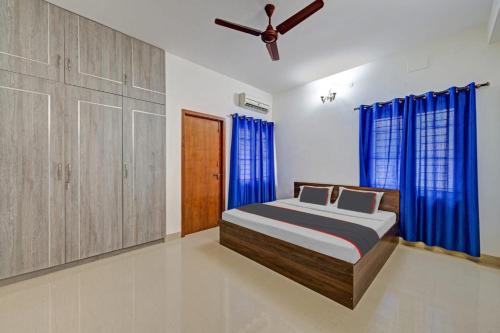 瓦拉納西的住宿－The Kutumb- Holiday Home，一间卧室配有一张带蓝色窗帘的床和吊扇