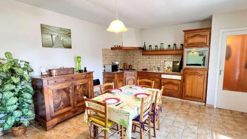 une cuisine avec une table et des chaises dans une pièce dans l'établissement Villa individuelle de plain pied, au calme, à La Flotte