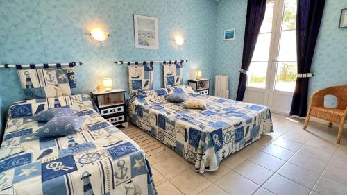 une chambre avec deux lits avec des draps bleus et blancs dans l'établissement Villa individuelle de plain pied, au calme, à La Flotte