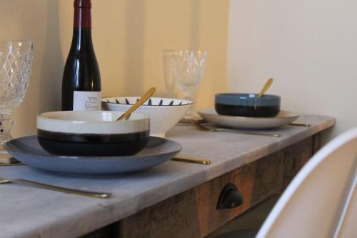 - une table avec 3 bols et une bouteille de vin dans l'établissement Studio cosy au pied du château, à Saumur