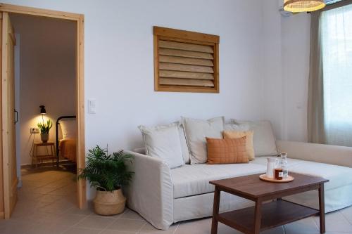 a living room with a white couch and a table at House of Hats II in Karavomylos